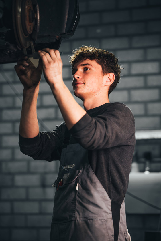 Mulder Van Mill monteur bezig met opgehangen auto